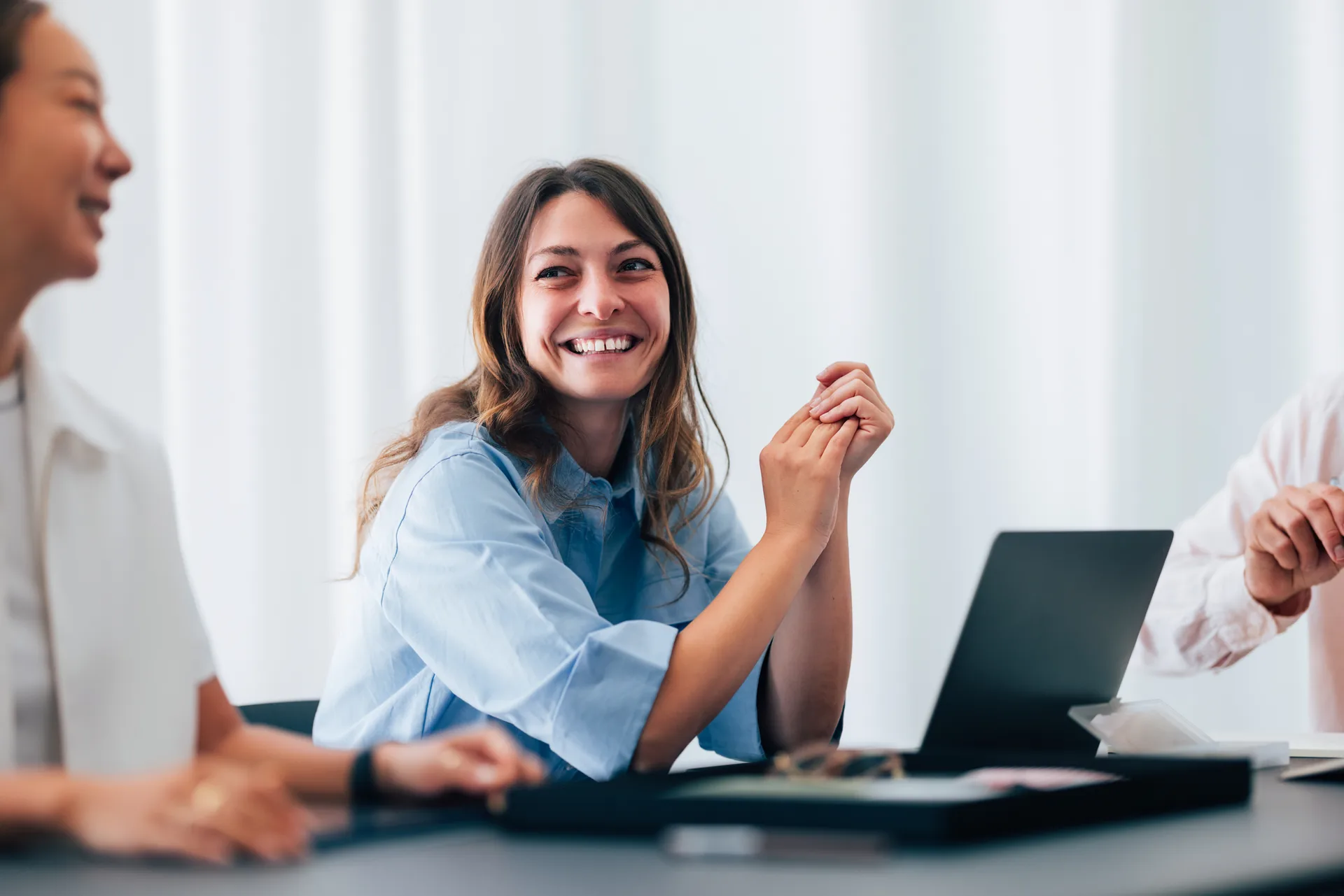 Réunion d'équipe avec une collaboratrice souriante - Val Solutions logiciel santé au travail